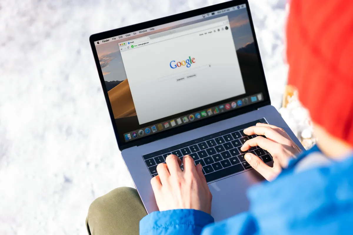 Persona buscando en Google desde su computador portátil